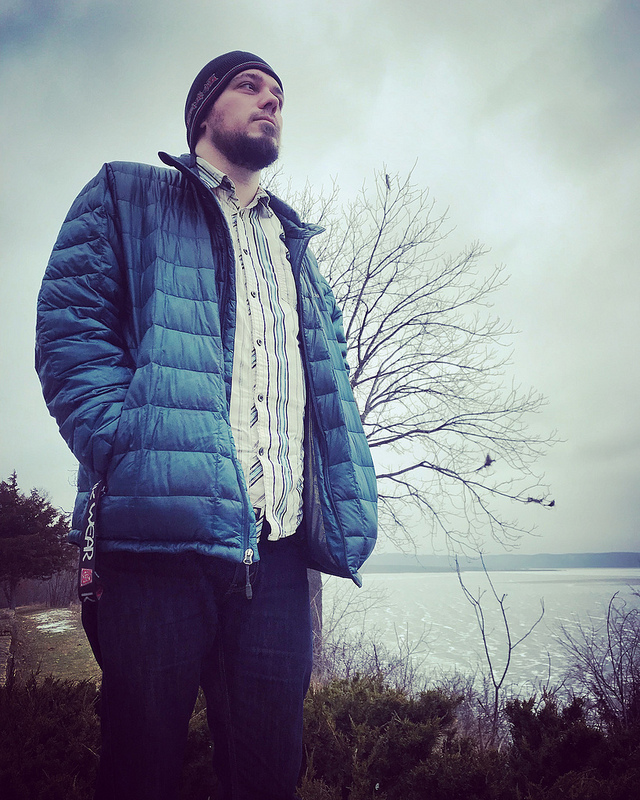 Man standing near Lake Pepin on a gloomy day