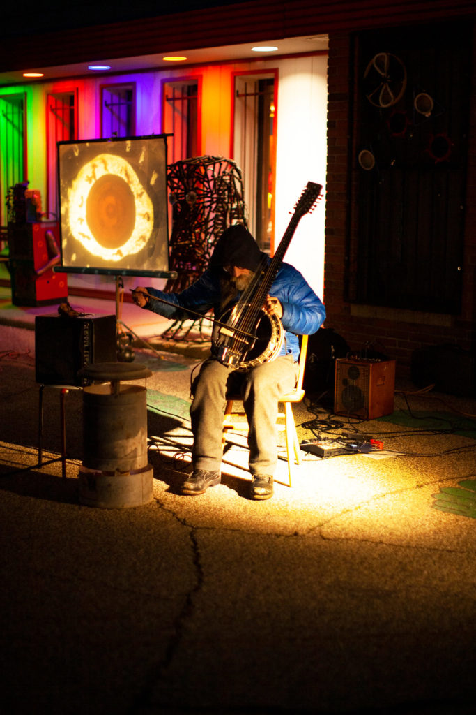 Paul Metzger playing banjo, outside, at night