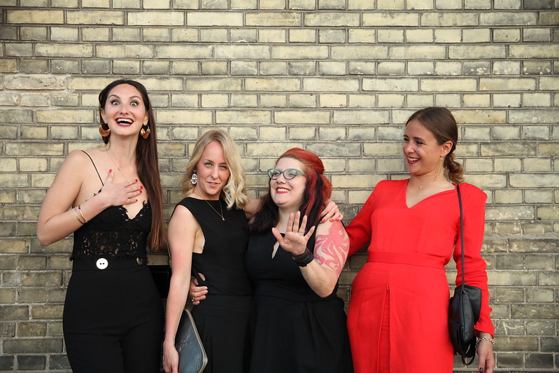 Group photo at a gala in front of a brick wall