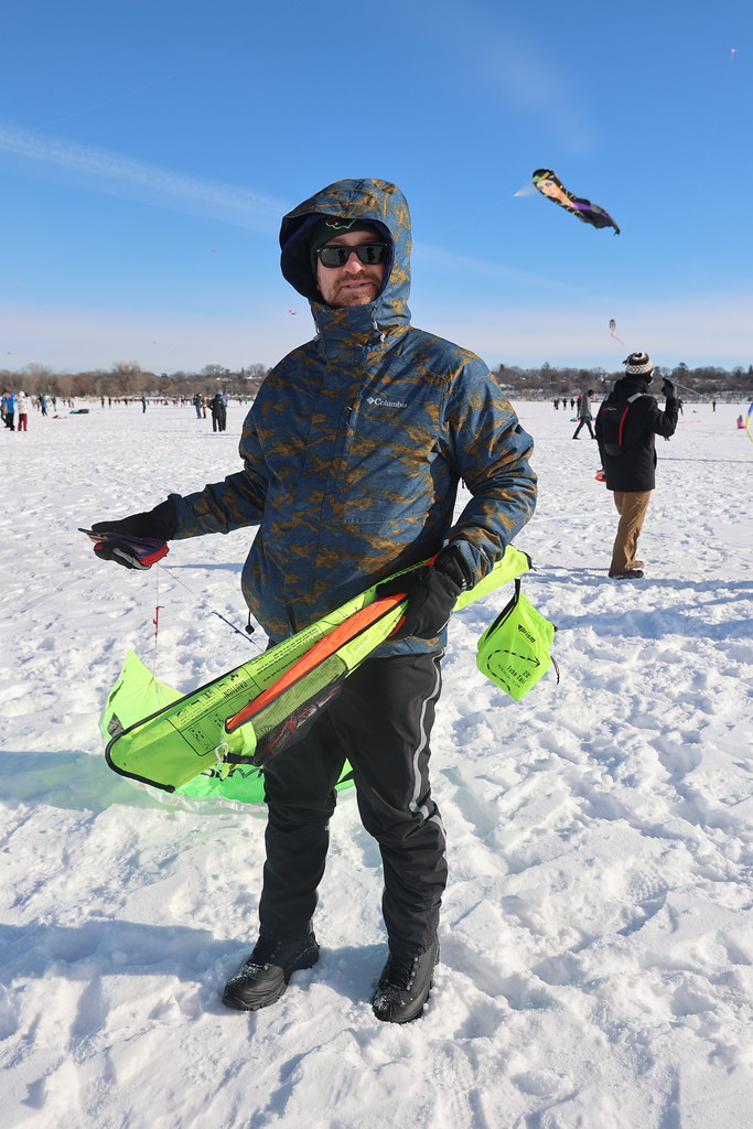 A man on a frozen lake preparing to fly a kite