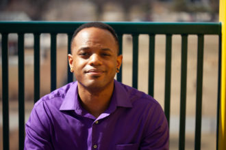 Lateef sitting on a bench on the Irene Hixon Whitney Bridge