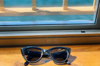 Sunglasses on a window ledge near water