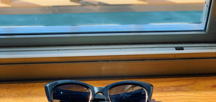 Sunglasses on a window ledge near water